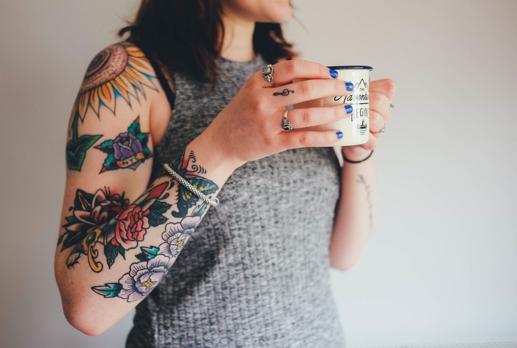 femme tatouée qui boit un café