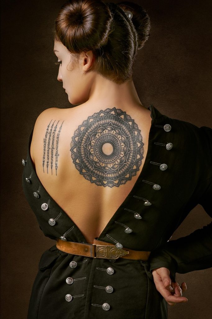 femme de dos qui montre son tatouage